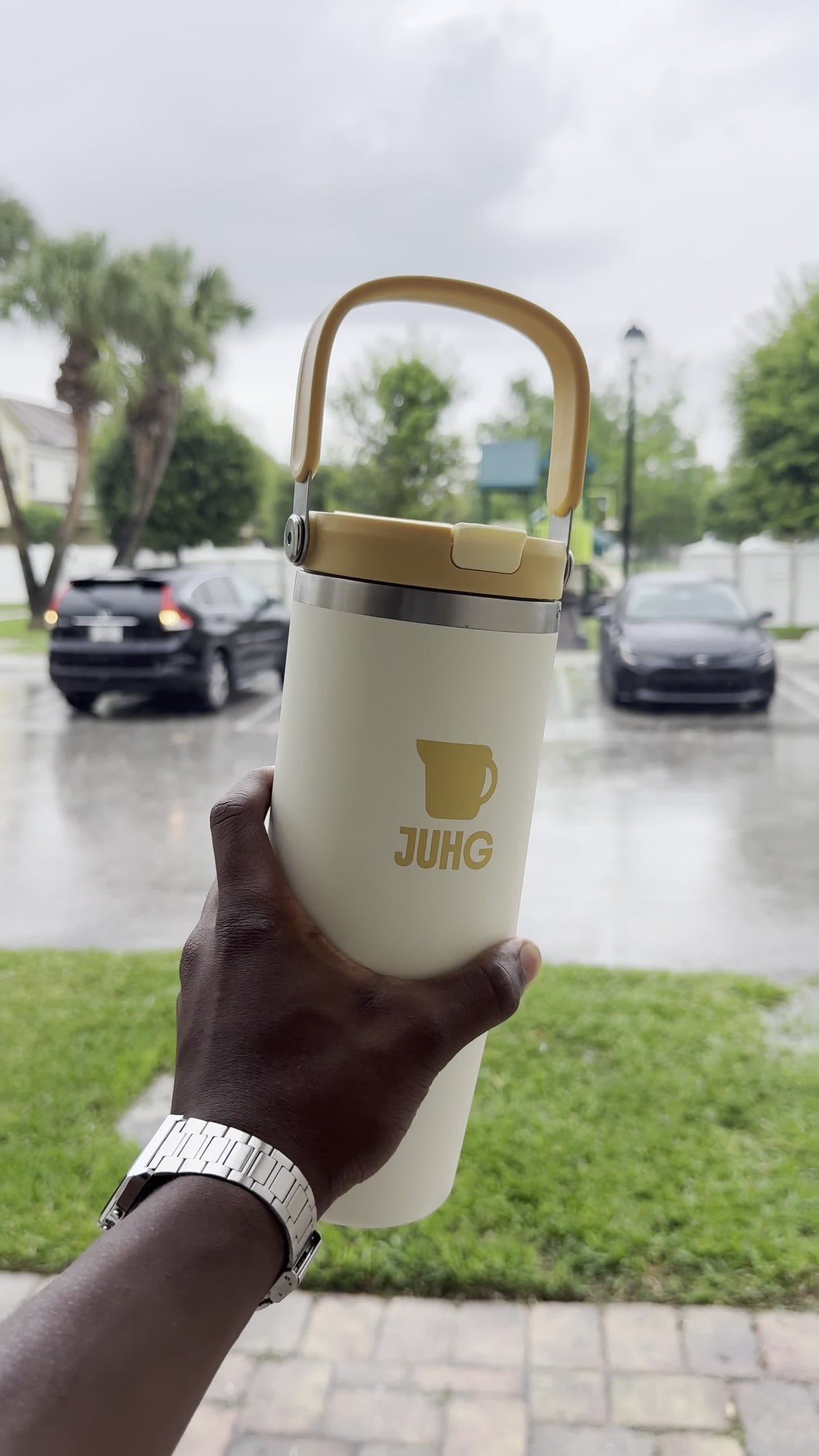 JUHG bottle held up outdoors on a rainy day